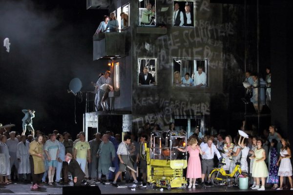 Die Prügelszene vor betontristen Fassaden. © Wilfried Hösl/Staatsoper München